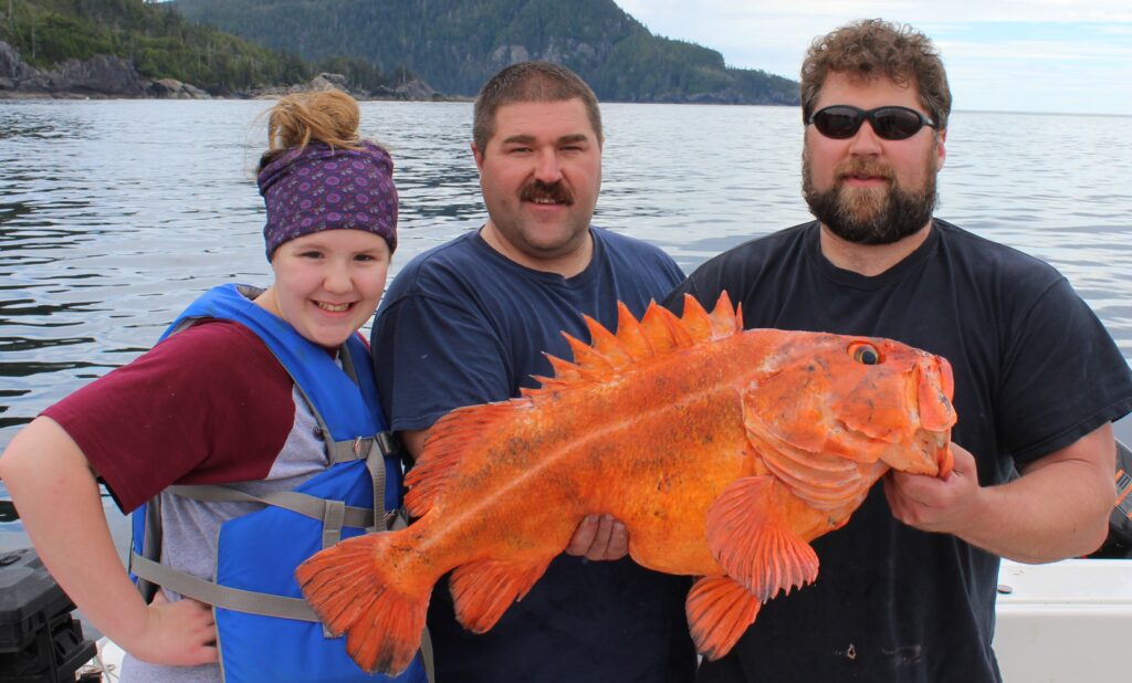 Ketchikan fishing report photo of Captain Cable, Lance, and Emma with a massive Yelloweye Rockfish about to be released.