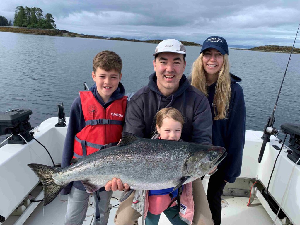 Guest family holding king salmon caught on a Ketchikan Alaska fishing charter