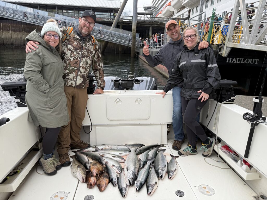 Ketchikan Alaska fishing charters photo showing four happy clients on the 4 C's boat with a great catch of fish by the cruise ship docks.