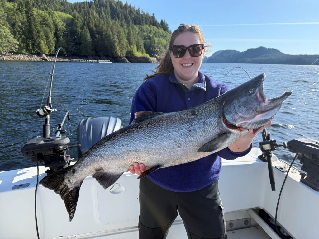 Emma Campbell holding a 20 lb King Salmon for our Ketchikan fishing report in Herring Cove during a bright, sunny day in Ketchikan.