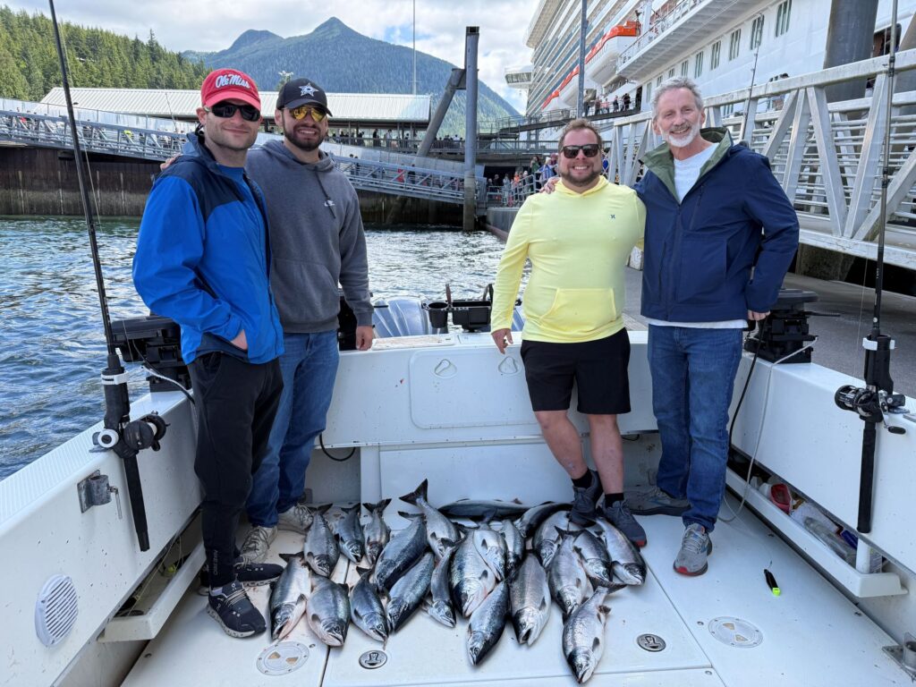 Ketchikan salmon fishing report photo showing a happy family holding a fresh catch of salmon on the 4 C's charter boat.